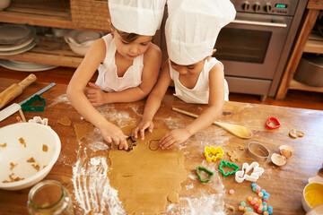 Family, baking and children learning to shape cookies at a table, development and bond in a...