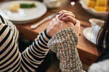 Hands, pray and family at a table for food, blessing and gratitude before sharing a meal in their...