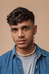 Young handsome stylish man with piercing looking at camera