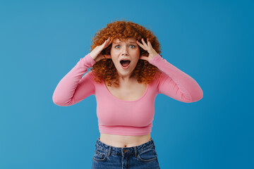 White ginger woman gesturing while expressing surprise at camera