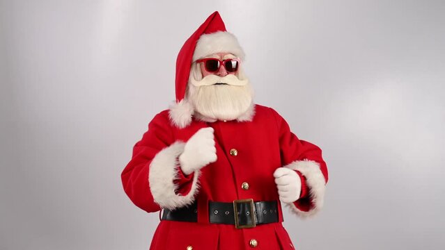 Santa claus in sunglasses dancing on a white background. Merry Christmas.