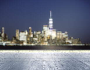 Empty concrete dirty seafront on the background of a beautiful blurry New York city skyline at...
