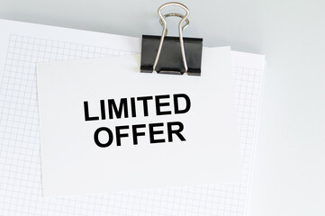 Limited offer inscription on the card on the clip to the notebook on a light background