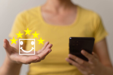 The concept of assessment after service. The hand is holding a star to increase the score, bringing it to a total of 5 stars. Full rating after impressive service.
