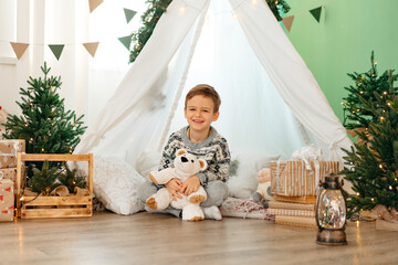 A little boy lying in a children's wigwam decorated for Christmas © fotofabrika