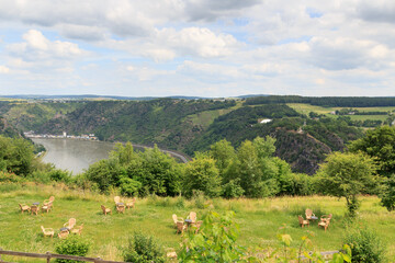 Fototapeta na wymiar River Rhine gorge panaroma with Lorelei rock and chairs and tables in St. Goar, Germany