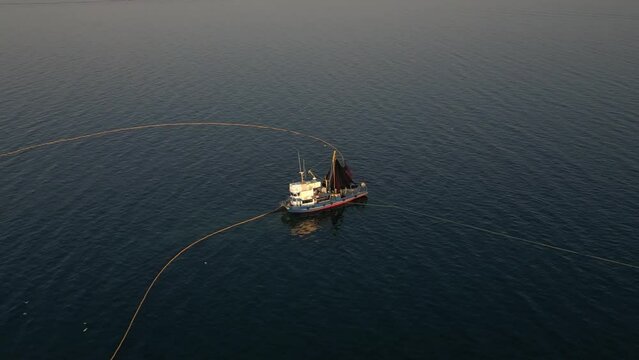 Aerial View of Fishing Ship and Net in Circle Shape, Collecting Fish From sea. Traditional Salmon Fishing in Izmir Turkey, Drone Shot. High quality 4k footage