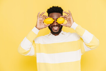 Happy bearded african american man smiling and holding lemons