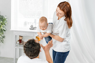 a man and a woman hug, play with a child, smile, rejoice. concept of happy family, childhood
