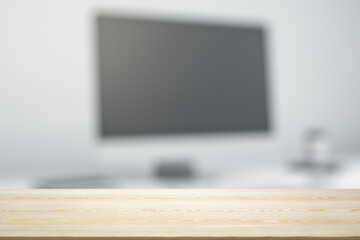 Blank wooden office desk with light workplace with laptop on background, mock up