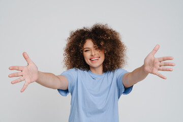 Young beautiful smiling curly woman with open arms