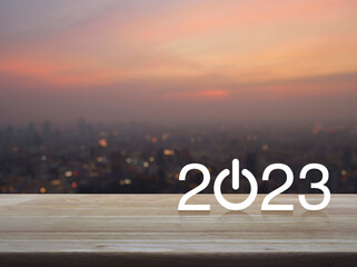 2023 start up business flat icon on wooden table over blur of cityscape on warm light sundown, Happy new year 2023 cover concept