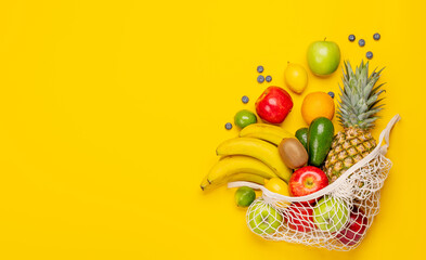 Shopping mesh bag full of healthy food on yellow