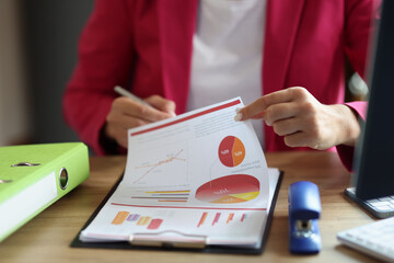 Female accountant holding financial report or signing papers