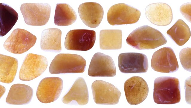 Red Aventurine jewel stones set texture on isolated white light background. Moving right seamless loop backdrop.