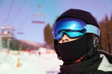 Skier in ski helmet and mask, space for text