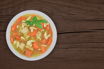 Home Cooked Chicken Noodle Soup on Wood Background with Copy Space