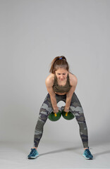 Training with kettlebells, a young athlete performs exercises with kettlebells, kettlebell lifting...