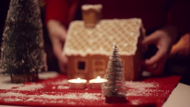 Women's hands move the gingerbread house