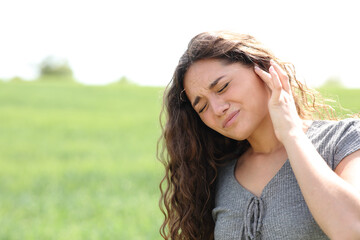 Woman suffering earache in a field