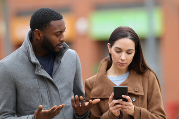 Woman using phone ignoring her friend in the street