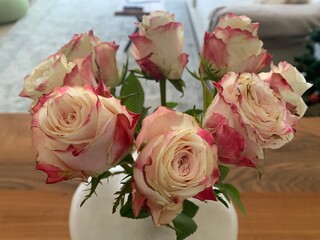 Close up image of a bouquet of pink and white roses in a vase