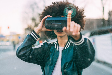 Young woman with afro hairstyle wearing VR glasses in front of transparent screen