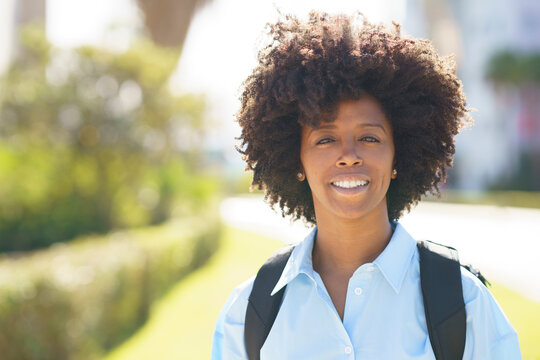 Happy student with afro hairstyle on sunny day