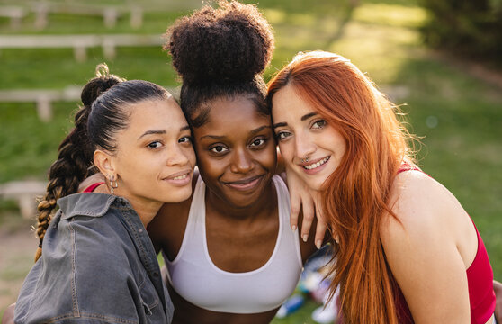 Happy young women standing together in park