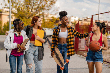 Young students having fun walking together on footpath