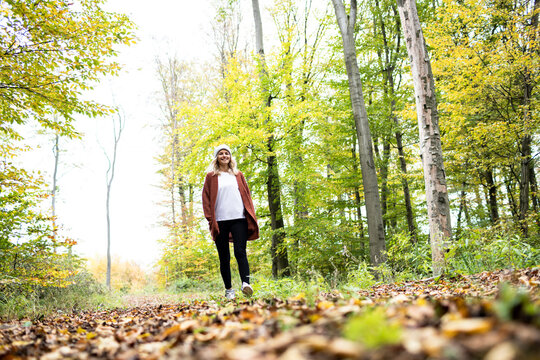 Mature Woman Exploring Forest On Weekend In Autumn