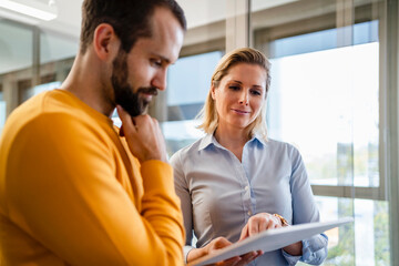 Business colleagues discussing over tablet PC at office