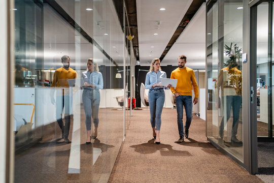 Business colleagues discussing over tablet PC in office