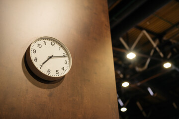 Clock on the wall indoors. Being late or arriving early concept. Arrows at seven and two. 10...