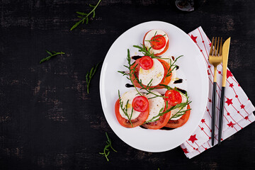 Salad Caprese with tomato, mozzarella and arugula in the shape of a Christmas tree. Top view, overhead