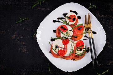 Salad Caprese with tomato, mozzarella and arugula in the shape of a Christmas tree. Top view, overhead