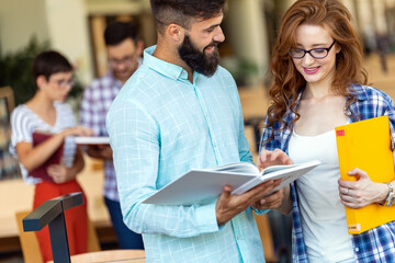 Happy group of success students studying and working together in a college library