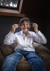 A boy with a white strand of hair is playing making a mustache from Christmas canes