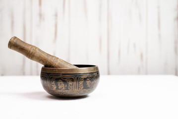 Singing bowl on a light wooden background.