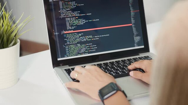 Programmer woman writing program HTML code sitting at workplace in office, IT software developer hands typing data coding programming with laptop computer, IT start up concept, Web application design