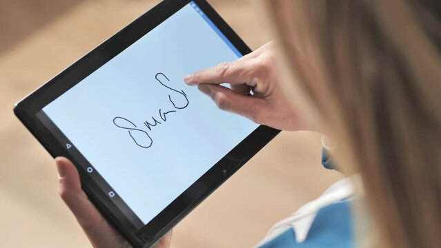 top view of woman signing document signature on tablet application