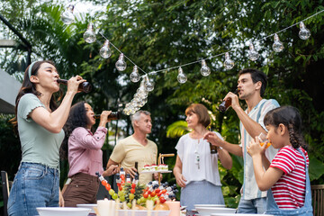 Multi-ethnic big family having fun, enjoy party outdoors in the garden. 