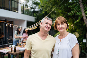 Obraz premium Portrait of senior couple looking at camera while having party outdoor.