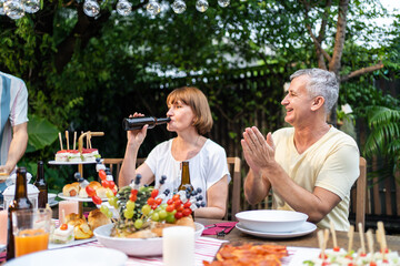 Multi-ethnic big family having fun, enjoy party outdoors in the garden. 