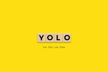 You Only Live Once (YOLO) Banner. Letter Tiles on Yellow Background. Minimal Aesthetics.