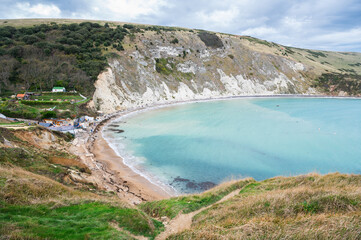 Beautiful views of Lulworth Cove in Dorset, United Kingdom. Part of Jurassic Coast World Heritage Site, view of stone cliffs and blue sea, selective focus