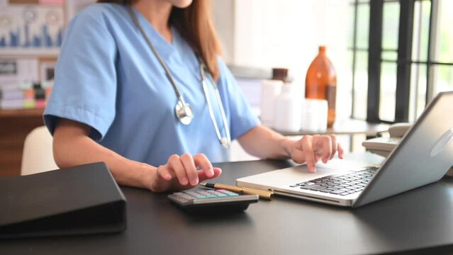 Healthcare costs and fees concept.Hand of smart doctor used a calculator and smartphone, tablet for medical costs at hospital