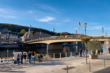 People hanging out next to Charles de Gaulle Bridge in Dinant