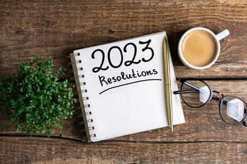 New year resolutions 2023 on desk. 2023 resolutions list with notebook, coffee cup on table. Goals, resolutions, plan, action, checklist concept. New Year 2023 template, copy space