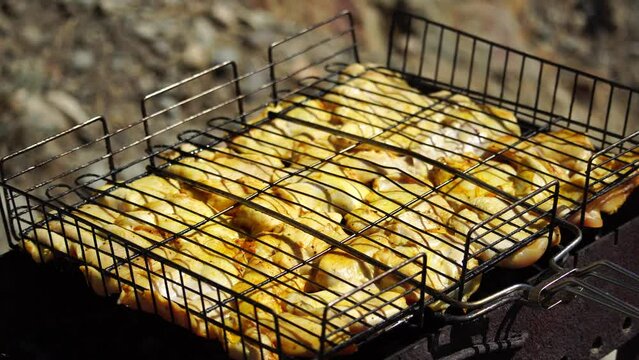 close-up of flattened out barbecued golden crispy skin chicken tabaka on grid, side view from above